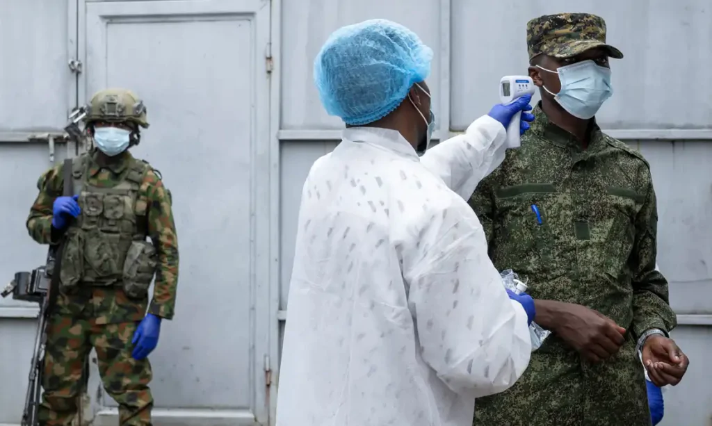 Pessoa vacinando militar contra o ebola