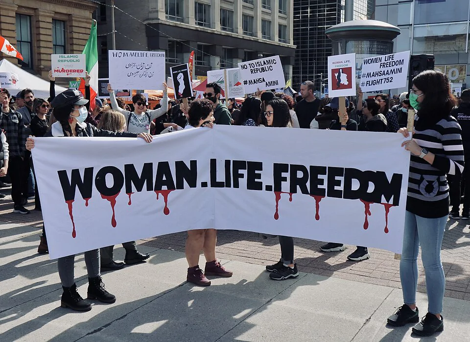 Foto de uma faixa com o lema "Mulher. Vida. Liberdade.", que nomeia o movimento feminista no Irã.