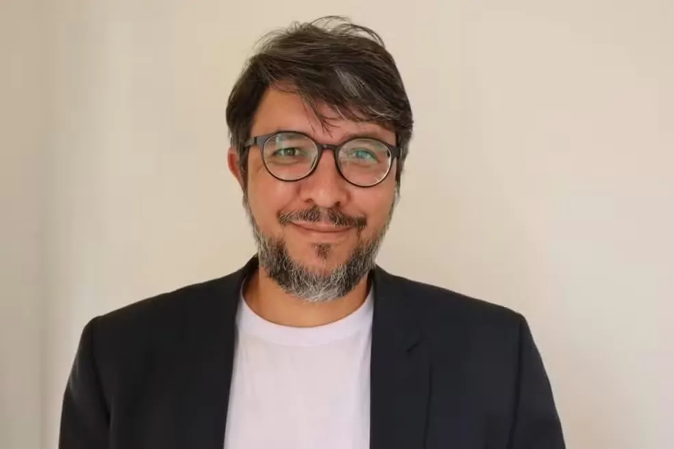 Homem branco de óculos sorrindo 