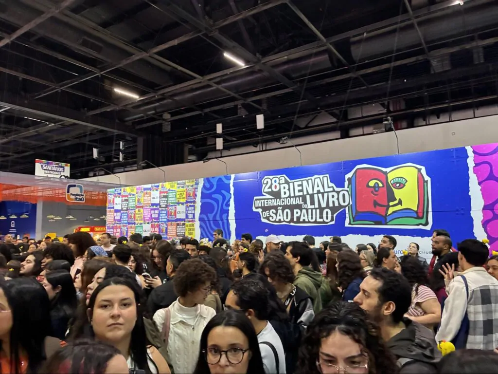 Visitantes e leitores circulando entre os estandes de editoras na Bienal Internacional do Livro.