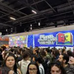 Visitantes e leitores circulando entre os estandes de editoras na Bienal Internacional do Livro.